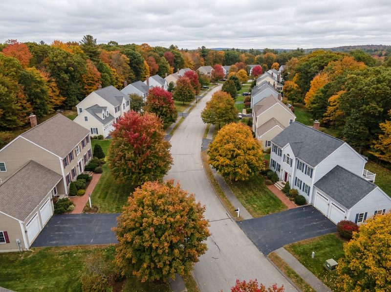 A New England suburban neighbourhood of colonial homes seen from above in autumn