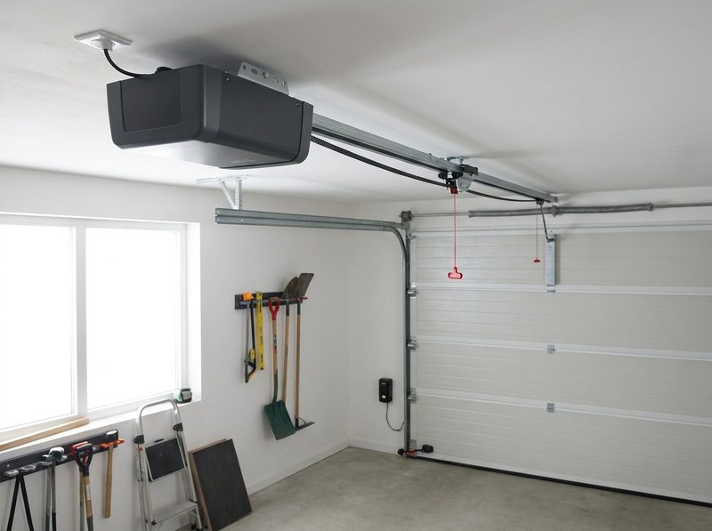 A belt-drive garage door opener mounted to a garage ceiling, rail running to the door